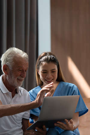 Doctors hold hands and give encouragement to elderly patients who are alone in the hospital's special room.の写真素材