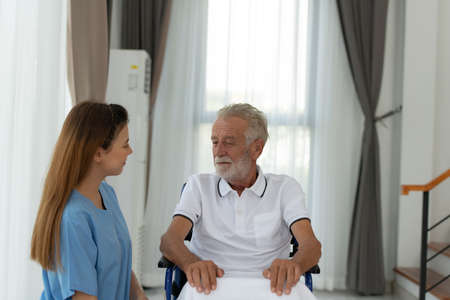 Doctors hold hands and give encouragement to elderly patients who are alone in the hospital's special room.の写真素材