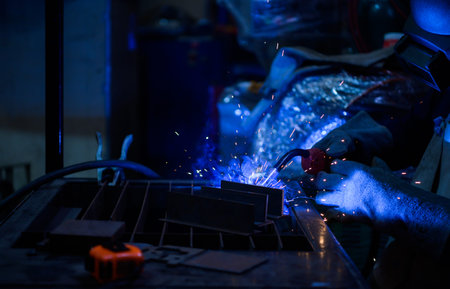A welder is working to weld metal. to create quality work according to the prescribed form