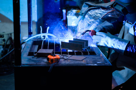 A welder is working to weld metal. to create quality work according to the prescribed form