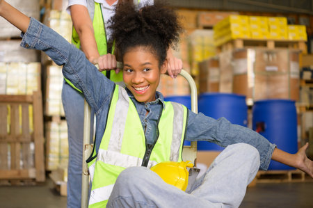 Two girls warehouse workers relax and play during the break of the day.の写真素材