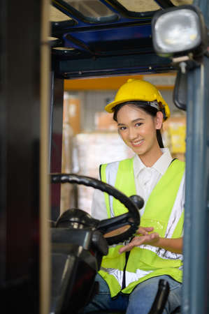 Female worker driving a forklift moving goods in the warehouse Practicing forklift operationの写真素材