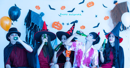 Asian young people five friends in costumes like zombie, witches and ghosts attend celebrate at...