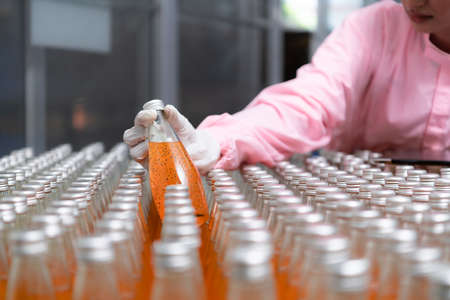 Product quality control staff at the fruit juice production line Perform product quality checks To ensure that the products produced are of good quality before being delivered to consumers furtherの写真素材