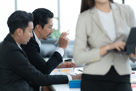 Young entrepreneurs in Asia Meeting to review stock investment information in the meeting room with a coordinator to facilitate various aspects to serveの写真素材
