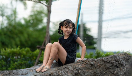 Childrens have fun playing mud slides in the community fields. with parents watching from a distance