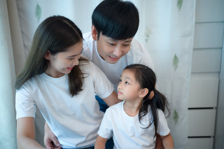 Family vacation, father and mother helping daughter practice in her piano lessons joyfully and happilyの写真素材