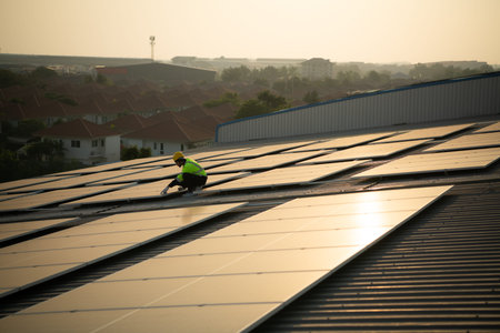 Technicians provide quarterly solar cell maintenance services on the factory roof under the evening...