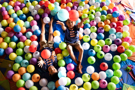 Childhood life in rural Thailand. A small child plays with colorful little hanging lamp used to decorate a house party.の写真素材