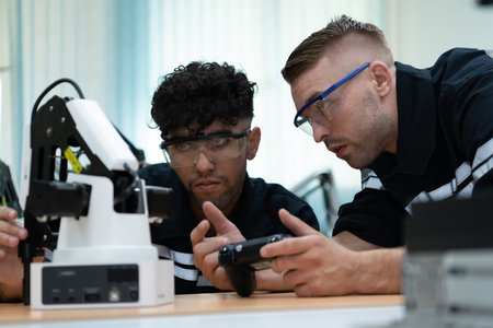 The robotic hand technology teacher is instructing new pupils on how to construct robotic hands for...