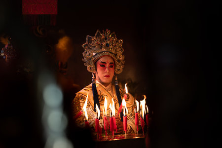 Male Chinese opera actors Light a candle to pray homage to the gods to enhance the prosperity for yourself on the occasion of the Chinese New Year festival.の写真素材