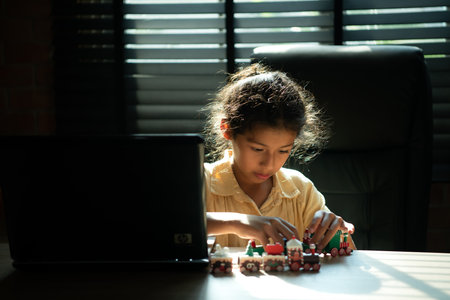 Portrait of little girl in the office room of house, They are having fun playing with toy trainsの写真素材