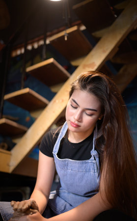 Pottery artist, Young female making a piece of clay molding calmly and meticulously In order to produce the most attractive work possible,の写真素材