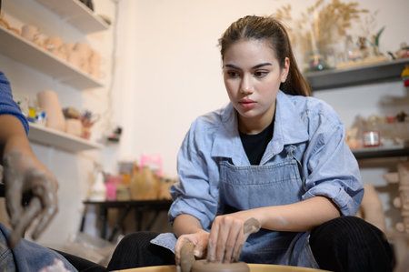 Pottery artist, Young female making a piece of clay molding calmly and meticulously In order to produce the most attractive work possible,の写真素材