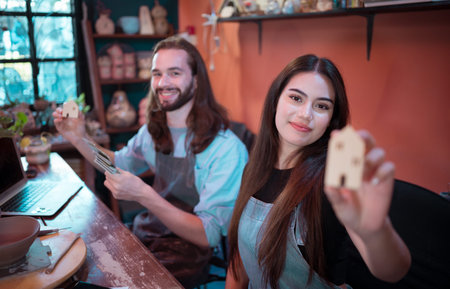 Two young entrepreneurs who own a pottery business. generate enough income from the business to expand the business to accommodate the increasing number of customersの写真素材