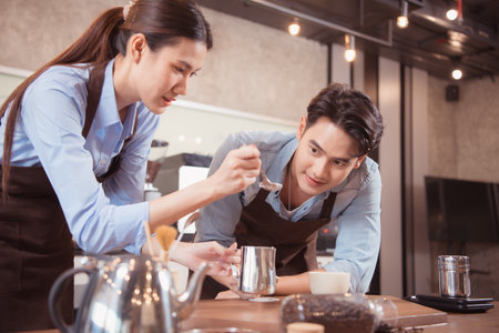 Before competing in the championship level coffee brewing competition, both of the baristas practice their coffee latte makeup techniques to become proficient.の写真素材