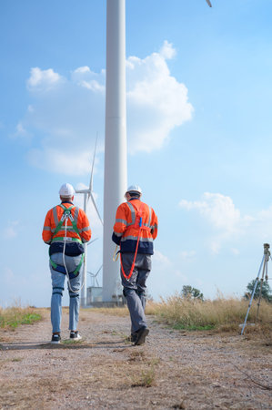 Surveyor and engineer Examine the efficiency of gigantic wind turbines that transform wind energy...