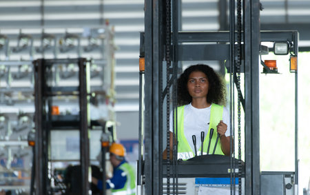 Worker in auto parts warehouse use a forklift to work to bring the box of auto parts into the storage shelf of the warehouse waiting for delivery to the car assembly lineの写真素材