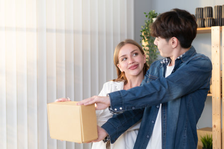 A young couple runs a small business making clay jewelry. They support one another as they work toward becoming larger business in the future.の写真素材