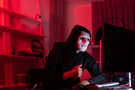 This is the face of a hacker who is knowledgeable with operating systems and other programs. He will exploit flaws and breach the computer system to cause damage.の写真素材
