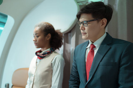 Flight attendant greet passengers as they enter the aircraft to locate a seat in the cabin.の写真素材