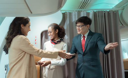 Flight attendant greet passengers as they enter the aircraft to locate a seat in the cabin.の写真素材