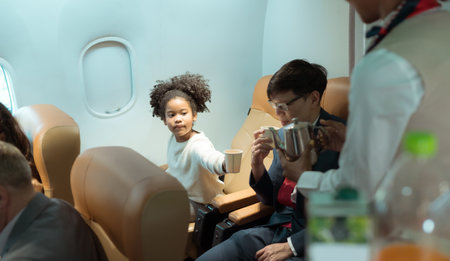 Flight attendant serving beverages to business class passengersの写真素材
