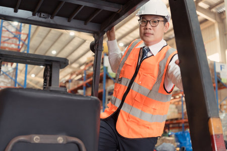Warehouse manager Examine the equipment used to move goods in the warehouse and test drive a forklift.の写真素材