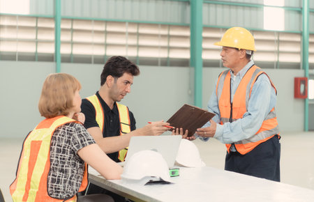 Meeting between designer and warehouse manager to organize the arrangement of product shelves in a huge, empty warehouse.の写真素材