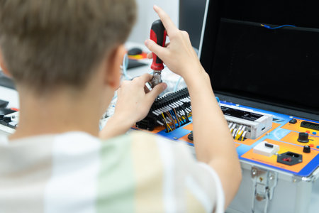 Youngsters utilizing the hand robot technology are having fun learning the electronic circuit board and hand robot controller of robot technology, which is one of the STEM courses.の写真素材