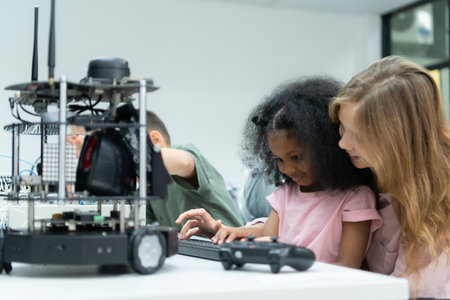 Youngsters utilizing the hand robot technology are having fun learning the electronic circuit board and hand robot controller of robot technology, which is one of the STEM courses.の写真素材
