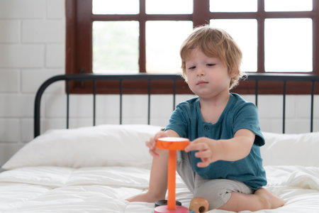 Little boy in his bedroom with a new toy purchased by his parents to help him improve his thinking skills.の写真素材