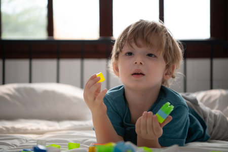Little boy in his bedroom with a new toy purchased by his parents to help him improve his thinking skills.の写真素材