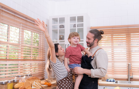 Mom and dad in the kitchen of the house with their small children. Have a good time making dinner together.の写真素材