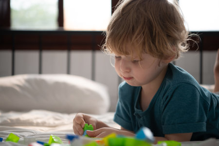 Little boy in his bedroom with a new toy purchased by his parents to help him improve his thinking skills.の写真素材