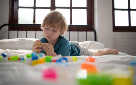 Little boy in his bedroom with a new toy purchased by his parents to help him improve his thinking skills.の写真素材