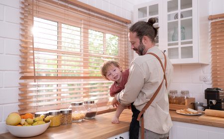 Father in the kitchen of the house with a small child. Play and have fun cooking dinner together.の写真素材