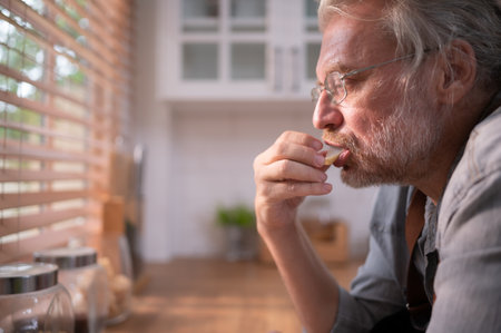 Grandpa in the kitchen with natural light, preparing for the day's dinner for the family.の写真素材