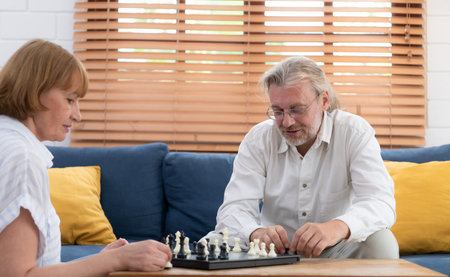 In the living room of the house, an elderly couple sits and relaxes. to begin playing chess together...