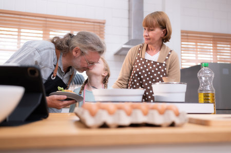 Grandparents with grandchildren and children gather in the kitchen to prepare the day's dinner.の写真素材
