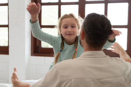 A little girl expresses his feelings for his father. By embracing as soon as you wake up in the beginning of the dayの写真素材