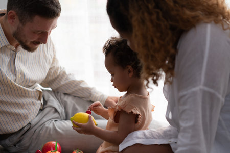 Parents and children relax in the living room of the house. Watch baby happily play with his favorite toy.の写真素材