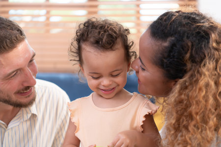 Parents and children relax in the living room of the house. Watch baby happily play with his favorite toy.の写真素材