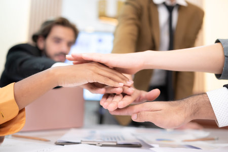 Businesspeople can motivate each other by joining hands.