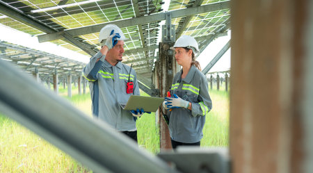 A team of electrical engineers is inspecting and maintaining solar panels at a solar panel site in...