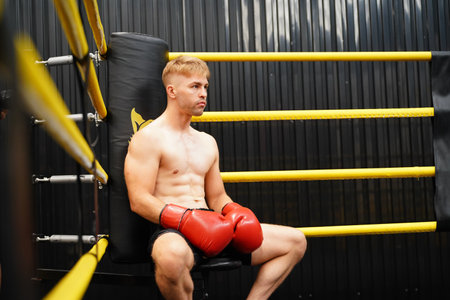 Muay Thai, The martial art of Thailand, Boxer sitting in the corner When the referee stops the fight in each round for the boxer to rest and the coach to introduce the fight in the next round.の写真素材