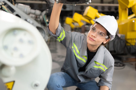 A female engineer installs a program on a robotics arm in a robot warehouse. And test the operation...