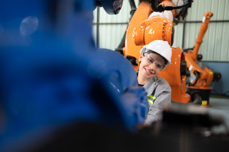 In the robots warehouse, A female engineer inspects the electrical system of every robotics arm, before delivering to the customer.の写真素材