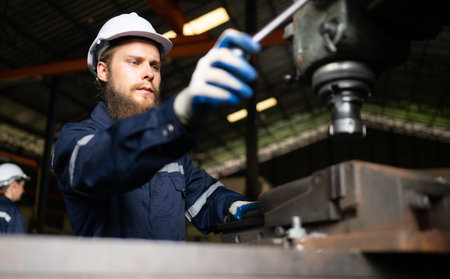 Portrait of mechanical engineers are checking the working condition of an old machine that has been used for some time. In a factory where natural light shines onto the workplaceの写真素材