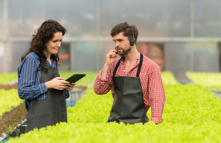 Two small businesspeople organic vegetable garden owner currently introducing customers and showing them his organic vegetable garden via online system.の写真素材